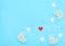 Text â€œI love momâ€ made of small pearl hearts with red felt heart and rattan, felt hearts, flower beads on blue background.