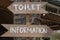 Text information and toilet on a wooden board of tropical Bali island, Indonesia. Information and toilet wooden sign inscription