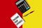 Text Keep track of your expenses, written on a notepad next to a calculator on a yellow-red background