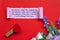 Text label on torn paper with flowers on red background. Valentine's Day concept