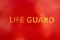 Text Life Guard sprayed a the wall of a life guard stand