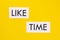 Text LIKE TIME on white paper on a yellow background.Social media concept