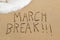 Text march break in the sand of a beach