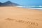 Text merry christmas in the sand of a beach