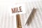 Text mile on paper card,pen, financial documentation on table - business, banking, finance and investment concept. close up of