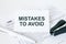 Text Mistakes To Avoid on note paper with white pen and stapler