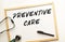 The text PREVENTIVE CARE is written on a white office board. Nearby is a stethoscope