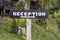 Text reception on a wooden board near tropical hotel in Borneo, Malaysia. Reception wooden sign inscription in the asian tropics