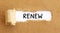 Text Renew appearing behind torn brown paper