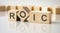 text ROIC written on wood toy cubes. text for your desing