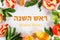 Text Rosh Hashanah on Hebrew. jewish New Year holiday concept. Traditional symbol. Apples, honey, pomegranate. Shana tova. Top vie