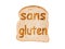 Text sans gluten (meaning gluten free in French) toasted on a slice of bread, isolated on white