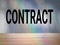 Text says Contract on cement wall background.  CONTRACT, text on concrete wall background with wood plank as a frame.