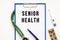 Text SENIOR HEALTH in the folder with the stethoscope. Medical concept.