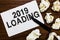 Text sign showing 2019 Loading. Conceptual photo Advertising the upcoming year Forecasting the future event Marker over notebook c