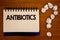 Text sign showing Antibiotics. Conceptual photos Drug used in treatment and prevention of bacterial infectionsIdeas on notebook wo