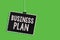 Text sign showing Business Plan. Conceptual photo Structural Strategy Goals and Objectives Financial Projections Hanging blackboar