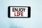 Text sign showing Enjoy Life. Conceptual photo Any thing, place,food or person, that makes you relax and happy Cell phone white sc