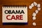 Text sign showing Obama Care. Conceptual photos Government Program of Insurance System Patient ProtectionIdeas on notebook wooden