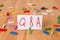 Text sign showing Q And A. Conceptual photo defined as questions being asked and answers Colored clothespin papers empty