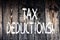 Text sign showing Tax Deductions. Conceptual photo Reduction on taxes Investment Savings Money Returns Wooden background