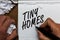 Text sign showing Tiny Homes. Conceptual photo houses contain one room only or two and small entrance Cheap Man holding marker not