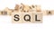text SQL - sales qualified lead - is written on three wooden cubes standing on a white table. in the background - a