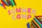 Text SUMMER CAMP of multicolored paper letters and colored felt-tip pens on a bright yellow background. top view. flat lay