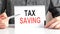 Text Tax Saving on white card with pen on financial table. Business and financial concept