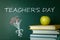 Text Teacher`s Day and bouquet drawing on chalkboard near stacked books with apple. Greeting card design