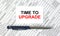 Text Time To Upgrade written on a business card lying on financial tables with a blue metal pen