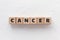 Text TOEIC on wooden cubes on white textured putty background. Abbreviation of `Test of English for International Communication