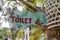 Text toilet on a wooden board of tropical Bali island, Indonesia. Vertical view of classic simple design handmade wooden sign of