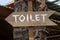Text toilet on a wooden board of tropical Bali island, Indonesia. Vertical view of classic simple design handmade wooden sign of