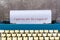 Text typed on an old blue classic typewriter on wooden desk.