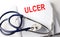 Text ULCER on a white background with stethoscope. Medical