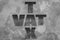 Text ` VAT ` TAX ` on old cement wall. Tariff wall concept