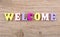 Text `WELCOME` of colored wooden letters