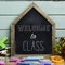 Text welcome to class in a house-shaped chalkboard