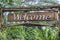 Text welcome on a wooden board in a rainforest jungle of tropical Bali island, Indonesia. Welcome wooden sign inscription in the