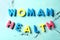 Text WOMAN HEALTH made of color letters on light background