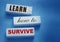 Text on wooden blocks Learn How to Survive. Surviving in crisis times business concept. Surviving during epidemy