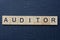 text on word auditor from gray wooden letters