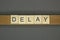 Text on word delay from gray wooden letters