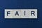 text on word fair from gray wooden letters