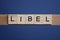 Text the word libel from brown wooden small letters