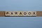 text the word paradox from brown wooden small letters