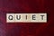 text the word quiet from gray wooden small letters