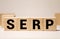 Text of the word SERP on wooden cubes on a black keyboard
