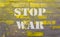 Text on yellow gray brick wall stop war